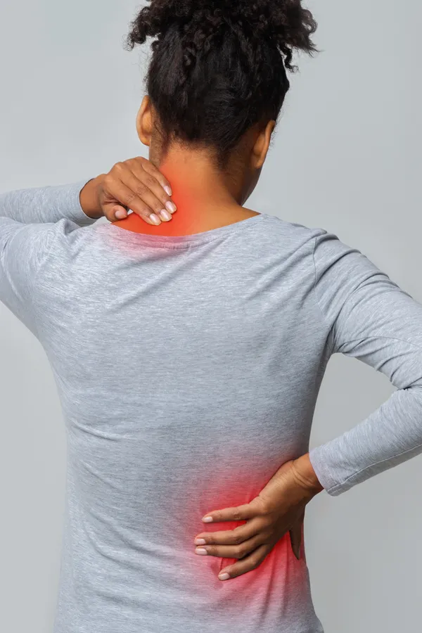 Fibromyalgia-Treatment An image from behind of a woman suffering from Fibromyalgia holding her hands on her neck and lower back. Get fibromyalgia treatment from Dr. Robert Powers of Eternal Vitality Orlando in Orlando.