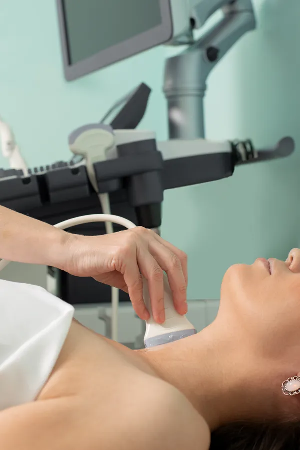 Hashimotos-Thyroiditis-Treatment A woman gets a thyroid scan from a doctor in a clinic. Get help with Hashimoto's Thyroiditis from Dr. Robert Powers of Eternal Vitality Orlando in Orlando.