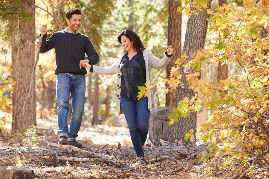 Lyme-Disease-Clinic A couple happily hiking in the forest in fall. Get treatment for Lyme Disease from Dr. Robert Powers of Eternal Vitality Orlando in Orlando.