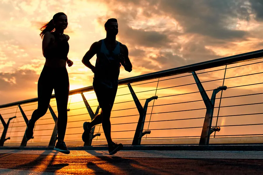 Performance-Enhancing-Peptides-Doctor A couple jogging on a bridge at sunrise, representing performance enhancing peptide therapy from Dr. Robert Powers of Eternal Vitality Orlando in Orlando.
