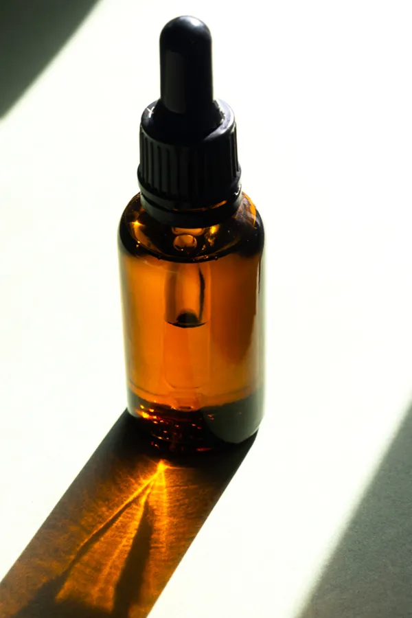 Performance-Enhancing-Peptides-Treatment A brown dropper bottle on a table lit by sunlight, representing performance enhancing peptide treatment from Dr. Robert Powers of Eternal Vitality Orlando in Orlando.