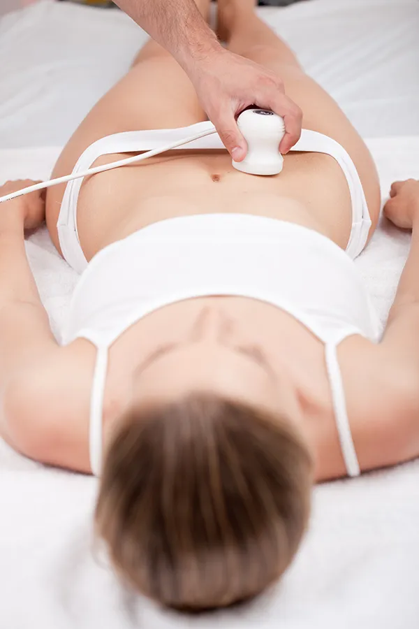 Radiofrequency-Body-Sculpting-Treatment A woman lays on a clinic bed getting Radiofrequency Body Sculpting treatment. Get Radiofrequency Body Sculpting treatments from Dr. Robert Powers of Eternal Vitality Orlando in Orlando.