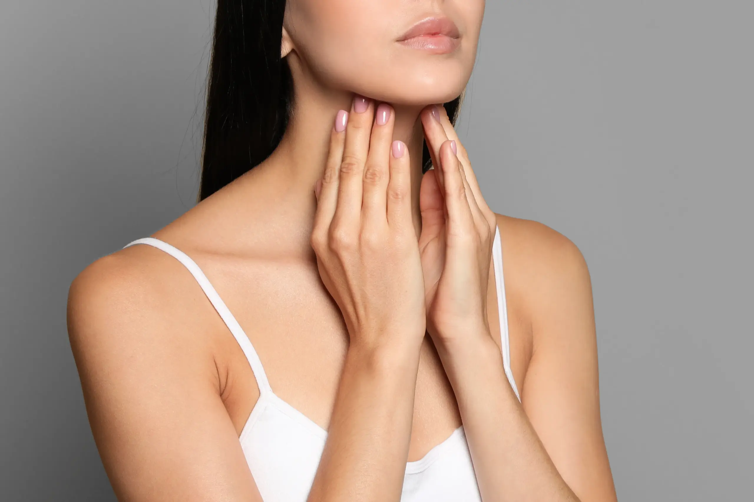 Thyroid-Doctor A woman in a white tank top touches her neck looking for signs of thyroid disorder. Get help for thyroid disorders from Dr. Robert Powers of Eternal Vitality Orlando in Orlando.
